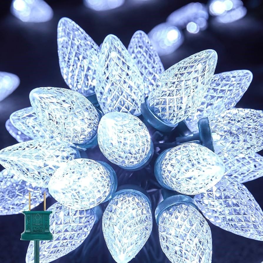 Close-up of illuminated faceted white LED bulbs clustered together with a green electrical plug visible.